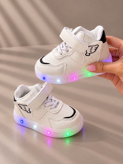 Tenis blancos con alitas y suela con luces de colores